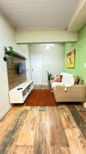 a living room with a couch and a tv at Cantinho Aconchegante in Volta Redonda