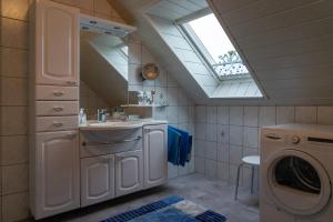 a bathroom with a sink and a washing machine at Ferienwohnung STEUERMANN in Werdum in Werdum