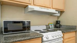 a kitchen with a white stove and a microwave at Plantation Hale Suites in Kapaa