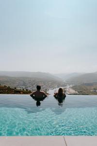 a man and a woman sitting in a swimming pool at Casa do Paço Suítes Douro Valley in Peso da Régua