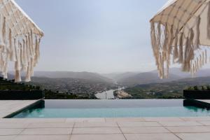 a swimming pool with a view of a lake at Casa do Paço Suítes Douro Valley in Peso da Régua