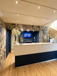 an office lobby with a reception desk and flowers at Hotel Liu in Lido di Camaiore