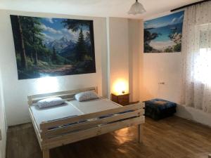 a bedroom with a bed with a painting on the wall at Smještaj Klekovača in Drvar