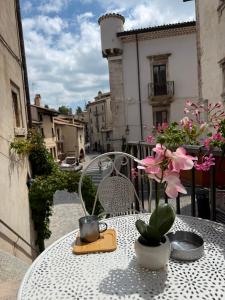 a table with a chair and flowers on a balcony at La Finestra Sul Paese in Pescocostanzo +1 photo