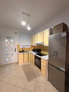 a kitchen with a stainless steel refrigerator and wooden cabinets at Zen Stay Maisonette in Igoumenitsa