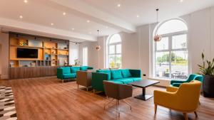 a living room with green chairs and a couch at Holiday Inn Darlington-A1 Scotch Corner by IHG in Scotch Corner