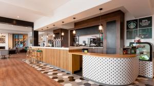 a bar in a restaurant with a checkered floor at Holiday Inn Darlington-A1 Scotch Corner by IHG in Scotch Corner