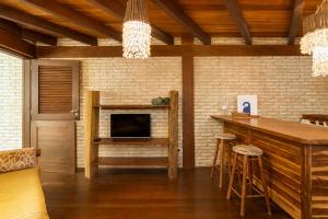 a living room with a bar and a fireplace at Casa Fufi in Jericoacoara