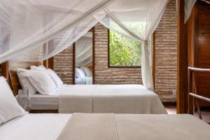 a bedroom with two beds and a window at Casa Fufi in Jericoacoara +61 photos