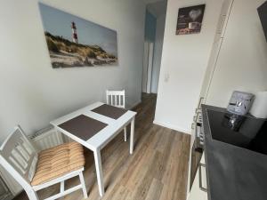 ein kleiner weißer Tisch und ein Stuhl in einem Zimmer in der Unterkunft Brigg in Emden + 6 Fotos