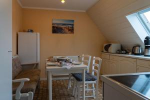 a kitchen with a table and chairs in a kitchen at Ferienwohnung SCHIFFSJUNGE in Werdum in Werdum