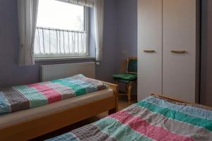 a small bedroom with two beds and a window at Ferienwohnung SCHIFFSJUNGE in Werdum in Werdum +8 photos