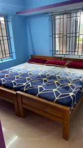 a bed with a blue and white comforter on it at ROYAL budget Rooms in Ooty