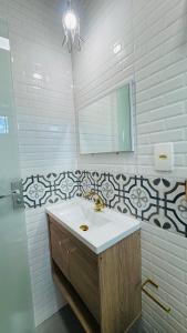 a bathroom with a sink and a mirror at Suíte Excellence - 02 in Pirenópolis