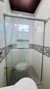 a glass shower in a bathroom with a toilet at Suíte Excellence - 02 in Pirenópolis