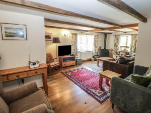 a living room with a couch and a tv at Green Farm Stables in Ashbourne