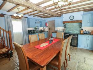 a kitchen with a wooden table with chairs around it at Green Farm Stables in Ashbourne