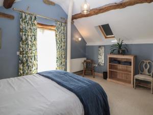 a bedroom with a large bed and a window at Green Farm Stables in Ashbourne