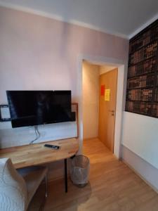 a living room with a large flat screen tv on a wall at Stadtrand Hotel in Hagen