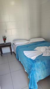 a bedroom with a bed with a blue blanket at Casa Verde in Morro de São Paulo