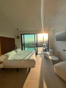 a bedroom with a bed and a living room with a view at Nidos de carnota in San Mamede de Carnota +26 photos