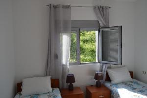a bedroom with two beds and a window at Guest House SAM-WATER in Đenovići