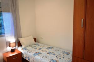 a bedroom with a bed and a lamp and a window at Guest House SAM-WATER in Đenovići