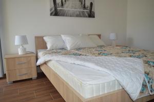 a bedroom with a bed and a nightstand with a picture on the wall at Guest House SAM-WATER in Đenovići
