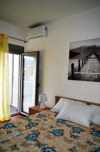 a bedroom with a bed with a painting on the wall at Guest House SAM-WATER in Đenovići