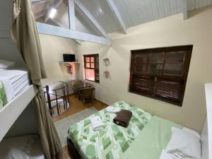 a bedroom with a bed and a table and a window at Pousada Reserva do Tombo Lounge Hostel in Guarujá +75 photos