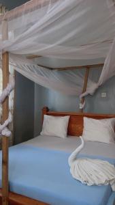 a bedroom with two bunk beds with white sheets at Paje Home away from home in Paje +15 photos