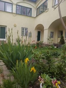 a garden in front of a house with flowers at Spacious Heritage Apartment for Groups in Bruck an der Leitha