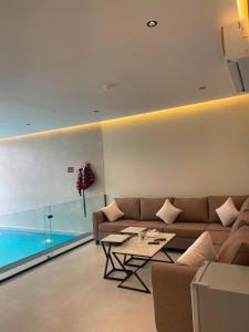 a living room with a couch and a table at بالم هيلز Palm Hills in Baljurashi