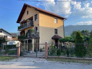 a house with a fence in front of it at Restful Garden Apartmants in Sarajevo