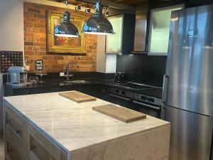a kitchen with a stainless steel refrigerator and a counter at Executive Corporate Penthouse in Woking +30 photos