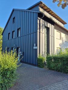 a black metal building with a garage at Ferienwohnung Debray in Winterberg
