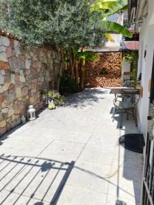 a patio with a table and a stone wall at La Bouganville in Arco