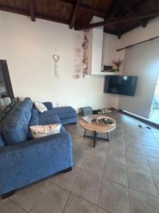 a living room with a blue couch and a table at Casa Gaia - Unit 1 in Glossa