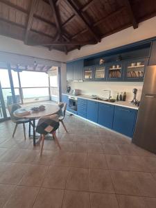 a kitchen with blue cabinets and a table and chairs at Casa Gaia - Unit 1 in Glossa