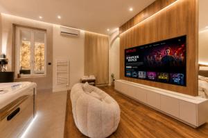 a living room with a large flat screen tv on a wall at Suite Prestige Spa Privatif D'exception in LʼIsle-Adam