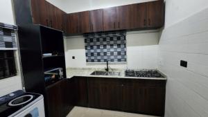 a small kitchen with a sink and a stove at LaCasa Abuja in Abuja
