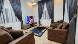 a living room with two couches and a television at LaCasa Abuja in Abuja