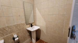 a bathroom with a sink and a mirror at LaCasa Abuja in Abuja