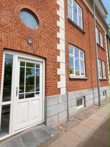 a brick building with a white door on it at Lejlighed midt i Thisted in Thisted +2 photos