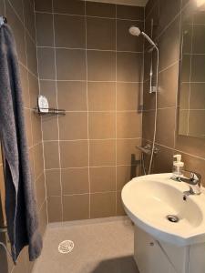 a bathroom with a white sink and a shower at Lejlighed midt i Thisted in Thisted