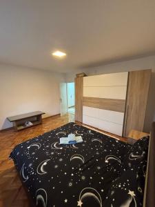 ein Schlafzimmer mit einem Bett mit schwarzer Bettdecke in der Unterkunft Stan Stefi in Pljevlja