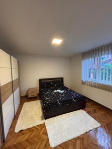 ein Schlafzimmer mit einem Bett in einem Zimmer mit Fenster in der Unterkunft Stan Stefi in Pljevlja + 1 Foto