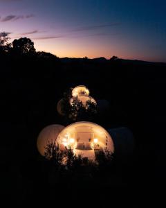 four domes lit up at night with the sunset at Burbujas cerca de Ronda in Ronda