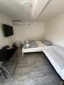 a bedroom with a bed and a desk and a tv at Lovor apartmani in Zelenika