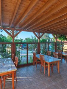 a patio with wooden tables and chairs and windows at Beli oblaki in Gradišče v Slovenskih Goricah